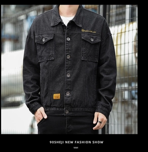 Detail of chest pocket with SERLUELIEF embroidery and orange label on denim jacket