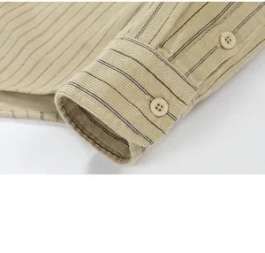 Detailed close-up of striped corduroy shirt cuff with a resin button and fine stitching