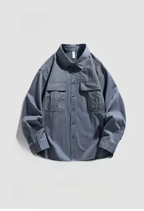 Macro detail of the oversized blue-grey workwear shirt featuring large flap chest pockets