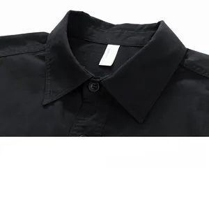 Detail of the black cotton shirt collar featuring neat stitching and a matte button