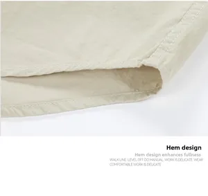 Close-up of beige cotton shirt hem showing precise double-needle stitching and twill texture