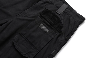 Detail der schwarzen Cargo-Hose mit großer Seitentasche, Klettverschluss und Nylonband
