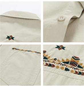 Detail view of ethnic embroidery patterns and resin buttons on a khaki long-sleeve shirt