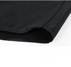 Detailed close-up of double-stitched hem on the black long-sleeve shirt top fabric
