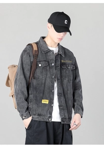 Close-up of vintage washed gray denim jacket with chest embroidery and yellow brand label