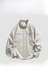 Detail of apricot corduroy shirt featuring ethnic embroidery on symmetrical chest pockets