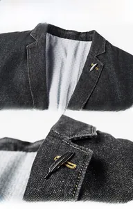 Detail of notch lapel with feather brooch on a men's dark grey denim blazer jacket