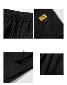 Detail view of black cargo shorts featuring drawstring waist and yellow brand woven label
