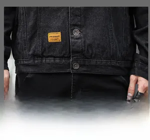 Detail of washed black denim jacket featuring silver metal buttons and yellow logo tag
