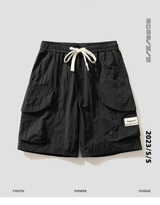 Detailed close-up of men's black cargo shorts featuring drawstring waist and flap pockets
