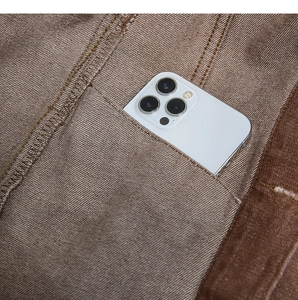 Dettaglio della tasca della giacca di jeans marrone con trama e capacità per smartphone