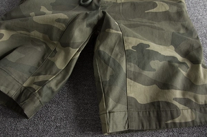 Detail of men's camo cargo shorts with elastic drawstring waist and reinforced stitching