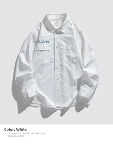 Detail of white cotton utility shirt showing double chest pockets and blue letter embroidery