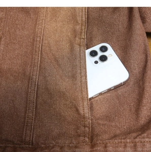 Dettaglio della tasca laterale di una giacca di jeans marrone con spazio per smartphone