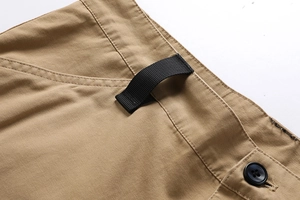 Detail der khakifarbenen Cargo-Shorts mit Seitentasche, schwarzer Schlaufe und Knopf