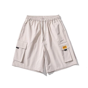 Detail view of cargo shorts pocket with adjustable drawstring and orange woven label