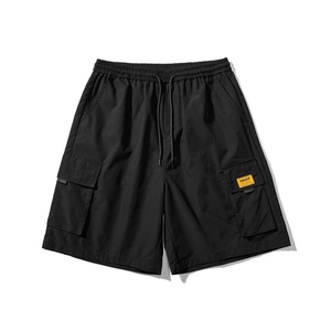 Close-up of black cargo shorts featuring elastic drawstring waist and yellow label detail