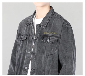 Detail of dark grey washed denim jacket featuring metal buttons and yellow logo embroidery