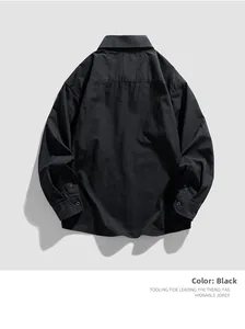 Flat lay of black long-sleeved workwear shirt showing fabric texture and stitching details