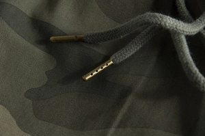 Detail of camouflage shorts showing twill cotton fabric and bronze metal aglets on drawstrings