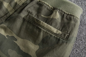Detail of military green camo shorts with elastic ribbed waistband and back welt pocket