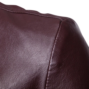 Macro shot of burgundy leather jacket shoulder showing grain texture and stitching