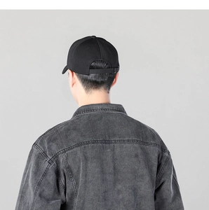 Rear view of black cotton baseball cap with adjustable metal buckle on a grey background
