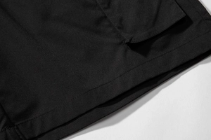 Detailed close-up showing reinforced stitching and flap pocket on black cargo shorts
