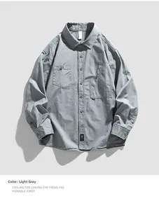 Close-up of light gray long-sleeve cotton shirt with asymmetric cargo pockets and brand label