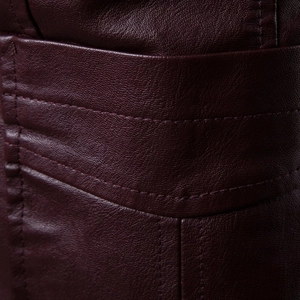 Detail of burgundy PU leather texture with high-quality stitching on jacket pocket