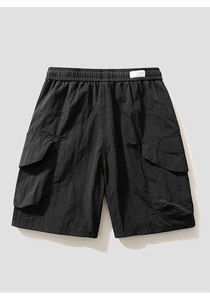 Detailed close-up of tactical black cargo shorts featuring elastic drawstring waist and side pockets