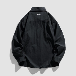 Back view of a black long-sleeved button-up shirt with classic collar and brand label
