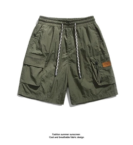 Detail of olive green cargo shorts featuring drawstring waist and ripstop nylon texture