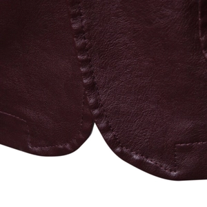 Macro shot of burgundy PU leather texture with detailed stitching on the jacket hem