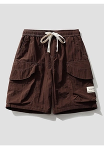 Detail of dark brown cargo shorts showing elastic waist with cream drawstrings and woven label