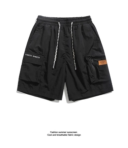 Close-up of black cargo shorts with elastic drawstring waist and street sports printing