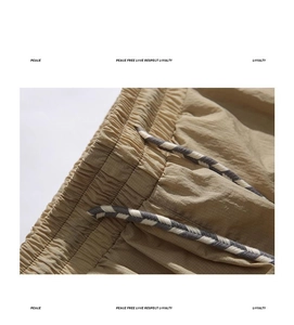 Detail of khaki cargo shorts waist featuring ripstop fabric and adjustable drawstrings