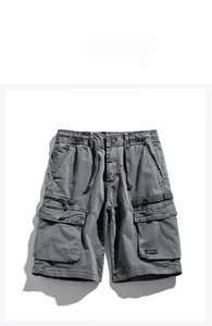 Detail of grey cargo shorts featuring elastic drawstring waist and large flap pockets