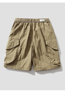 Close-up of khaki cargo shorts showing elastic waistband and large side flap pockets