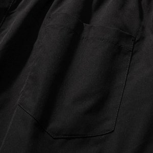 Men's loose cargo shorts in black featuring a functional patch pocket and sharp stitching