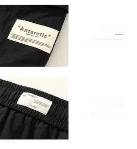 Detail view of black cargo shorts with a white woven label and sharp textile texture