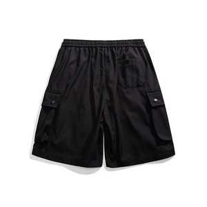 Detail view of elastic waistband and cargo pockets on black utility shorts