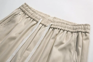 Close-up of elastic waistband with white flat drawstring on beige cargo shorts