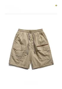 Detail of khaki cargo shorts showing elastic drawstring waist and side pocket with text