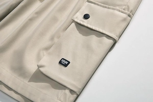 Macro detail of khaki cargo shorts pocket with button flap and brand label