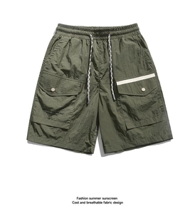 Detail of army green cargo shorts showing nylon fabric texture and drawstring waist