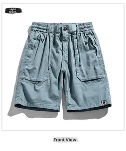 Detail view of light green cargo shorts featuring elastic waist and large side pockets