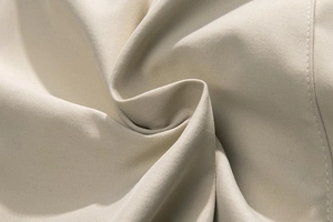 Macro view of beige cargo shorts fabric with fine stitching and durable textile texture