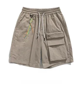 Detail of khaki cargo shorts showing elastic waist with drawstring and side pocket