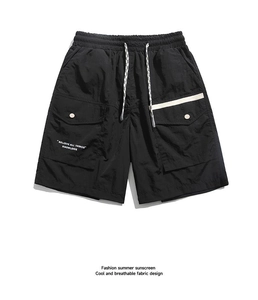 Detail of black cargo shorts featuring drawstring waist and large utility pockets